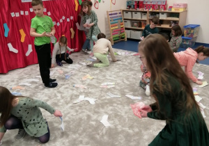 22 dzieci układają kolorowe skarpetki na dywanie.jpg